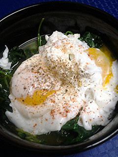 A picture of Poached eggs on a nest of spinach.