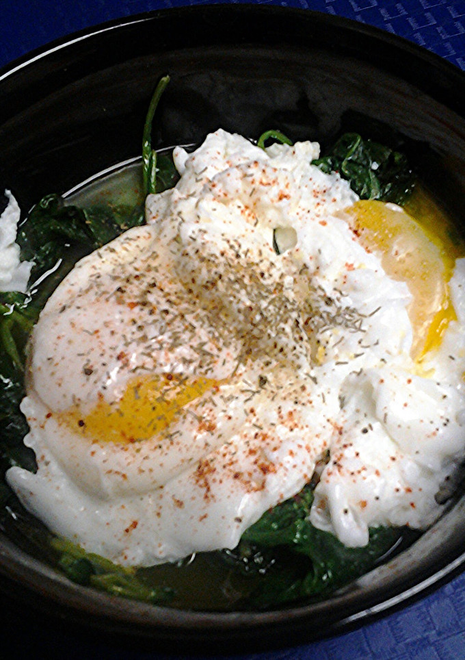 A picture of Poached eggs on a nest of spinach.