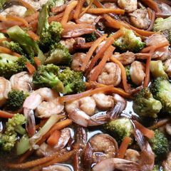 A picture of Prawns with vegetables in light sauce.