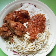 A picture of Rice and spaghetti with chicken stew.