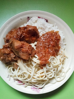 A picture of Rice and spaghetti with chicken stew.