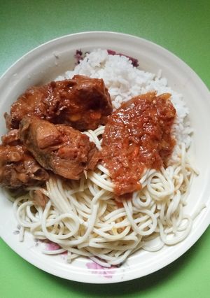 A picture of Rice and spaghetti with chicken stew.