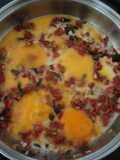 Huevos rancheros de tocino, chorizo, jamón y chiles de agua