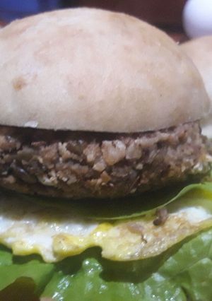 Una foto de Sándwich de burger de lentejas con huevo y lechuga con pan de cebolla casero