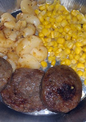A picture of round breakfast sausage with potatoes.