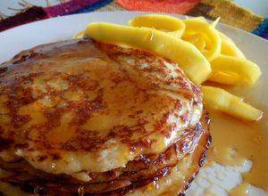 Una foto de Panqueques de coco con mango y almíbar de limón
