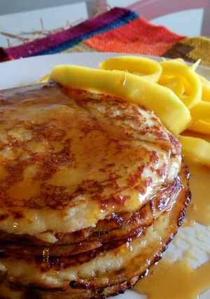Una foto de Panqueques de coco con mango y almíbar de limón