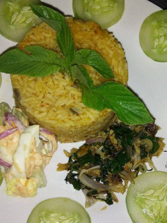 A picture of Jollof Rice with Coleslaw and Dried Fish.