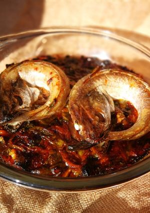 Una foto de Merlucitas sobre cama de verduras al horno