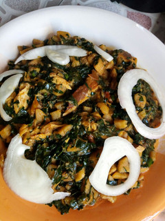 A picture of Unripe plantain porridge with smoked fish and vegetables.