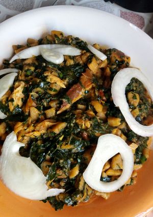 A picture of Unripe plantain porridge with smoked fish and vegetables.