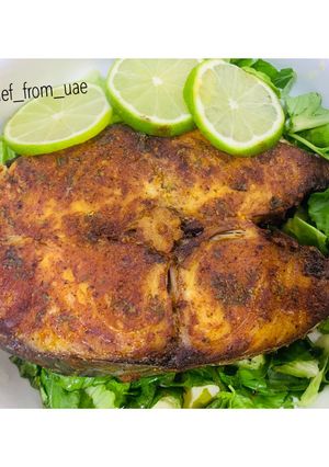 A picture of Baked Tilapia Fish served with rocket leaves.