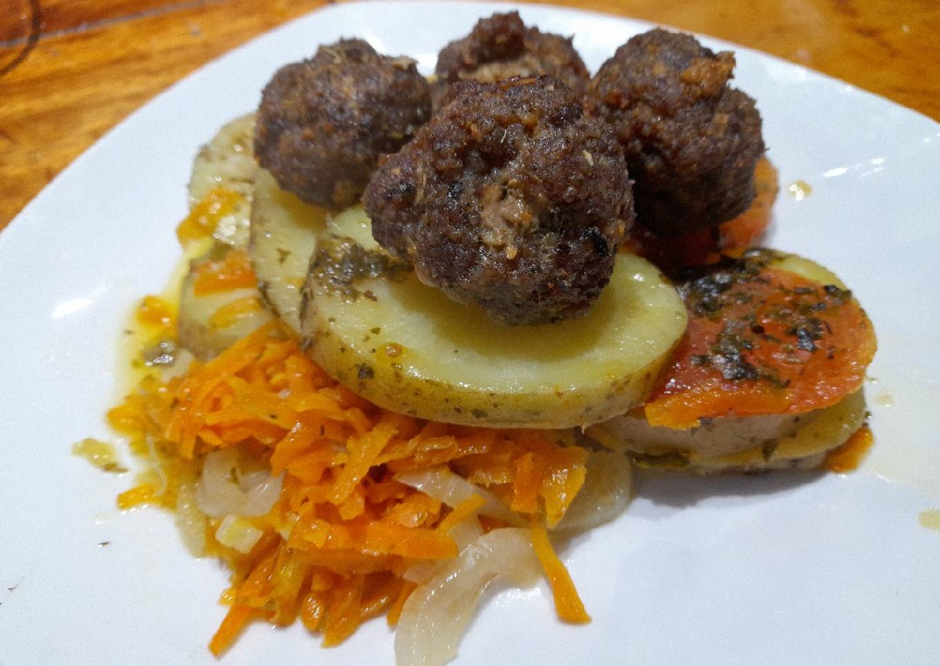 Verduras rehogadas coronadas con albóndigas doradas
