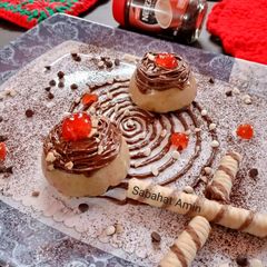 A picture of Coffee panacotta with hazelnut spread spirals and crushed wafers.