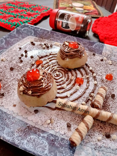 A picture of Coffee panacotta with hazelnut spread spirals and crushed wafers.