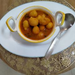 A picture of Moong dal and posto savoury laddu curry.