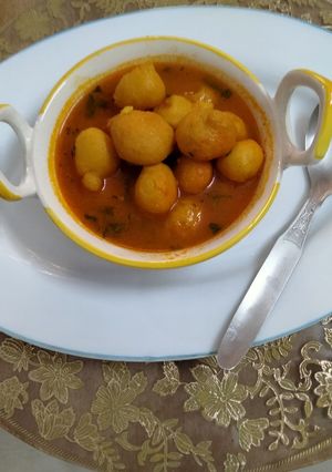 A picture of Moong dal and posto savoury laddu curry.