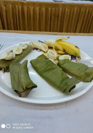 A picture of Steamed banana cake wrapped in banana leaves.