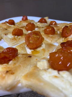 Una foto de Hojaldritos de queso de cabra, cebolla caramelizada y cherry