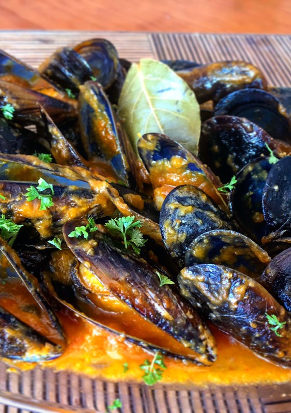 Una foto de Mejillones con pota en salsa al curry