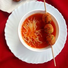 A picture of Mexican tomato soup with cottage cheese balls.
