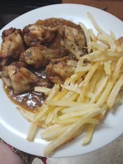 Una foto de Jamoncitos de pollo adobados y asados en freidora de aire con salsa de Cola-Cola y papas fritas