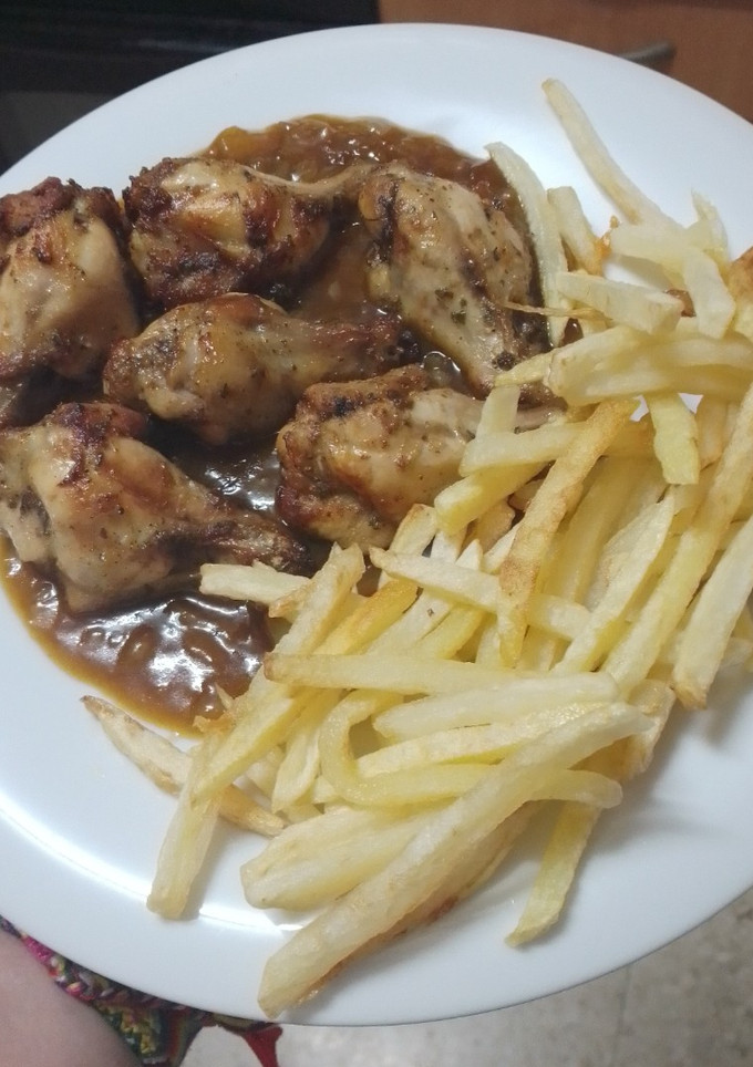 Una foto de Jamoncitos de pollo adobados y asados en freidora de aire con salsa de Cola-Cola y papas fritas