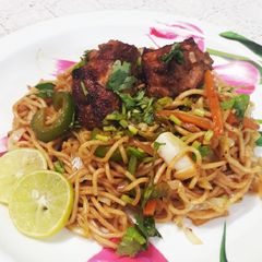 A picture of Peri peri noodles with pan fried chicken.