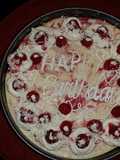 White chocolate raspberry swirl cheesecake topped with raspberries and sauce