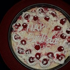 A picture of White chocolate raspberry swirl cheesecake topped with raspberries and sauce.