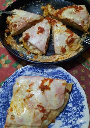 Una foto de Pizza con pernil, salsa de morrón, cebolla y tomate