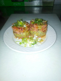 Una foto de Tartar de Salmón con base de Guacamole de tomate y cebolla roja