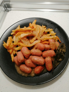 Una foto de Salchichas al vino acompañado de patatas fritas