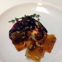A picture of Roasted feta with Cava, thyme, blueberry compote and glass candy with toasted fennel and pecans.