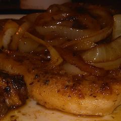 A picture of Seared pork chop with onions.