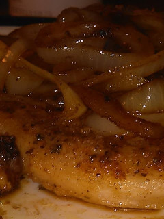 A picture of Seared pork chop with onions.