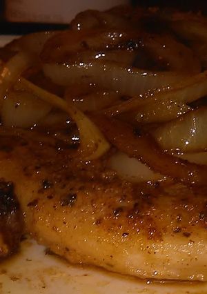 A picture of Seared pork chop with onions.