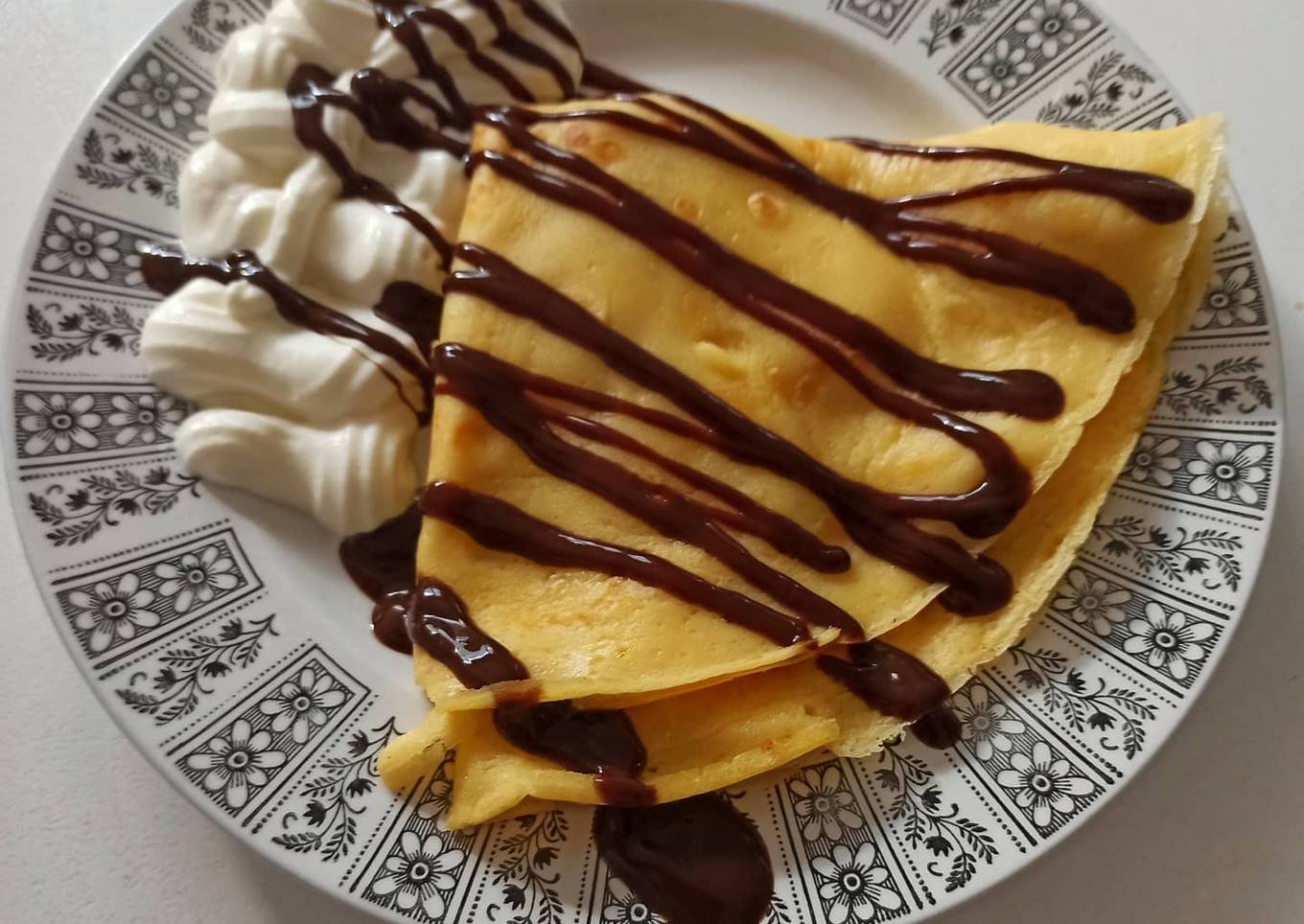 Crêpes con plátano, sirope de chocolate y nata