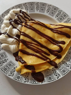 Una foto de Crêpes con plátano, sirope de chocolate y nata