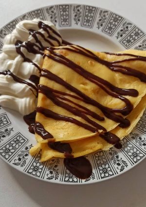 Una foto de Crêpes con plátano, sirope de chocolate y nata