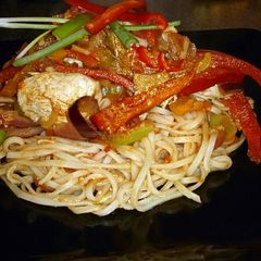 A picture of Chinese chicken stir fry with egg noodles.