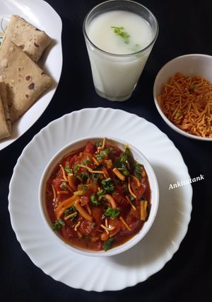 A picture of Sev Tomato Sabji - Gujarati dinner sabji with butter roti.