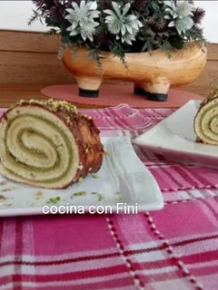 Una foto de Brazo gitano de claras relleno de crema de pistacho y bañado en chocolate