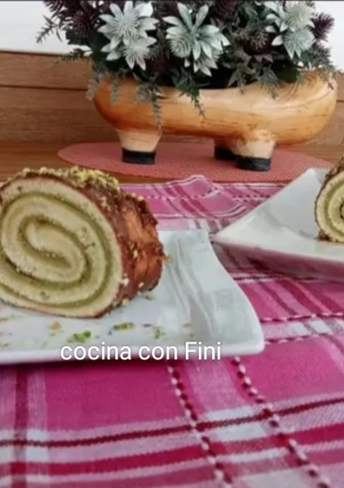 Una foto de Brazo gitano de claras relleno de crema de pistacho y bañado en chocolate
