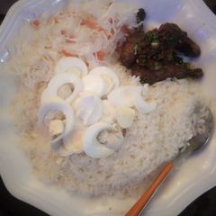 A picture of White rice and cabage,carrot with pepper chicken and boiled eggs.