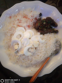 A picture of White rice and cabage,carrot with pepper chicken and boiled eggs.