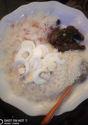 A picture of White rice and cabage,carrot with pepper chicken and boiled eggs.