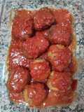 Bolas de carne rellenas de huevo cocido con salsa de tomate