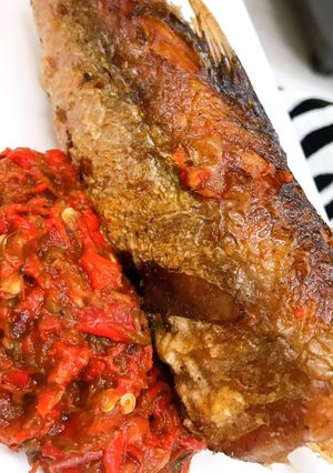 A picture of Roasted pepper sauce and fried hake fish.