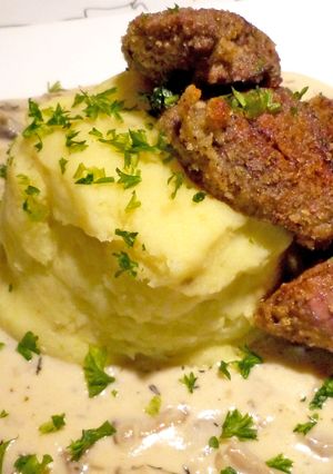 A picture of Chicken livers with mushroom sauce on garlic hash.